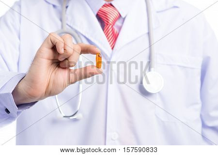 Omega 3 fish oil capsule hold by a male doctor hand
