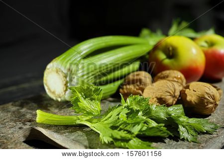 Ingredients for Waldorf salad - celery apples walnuts - fresh and healthy vegetables on granite board.