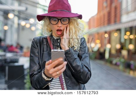 Woman looking at her phone in shock