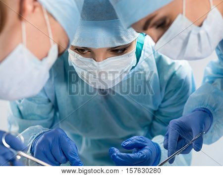 Medical Team Performing Operation. Group Of Surgeon At Work In Operating Theatre