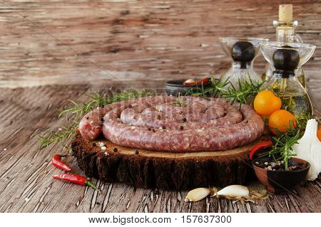raw beef sausages with rosemary and spices on a wooden table, South African boerewors