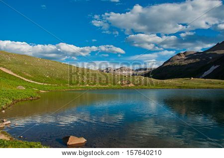Amazing Colorado Landscape high altitude Lake sitting calm with blue reflecting off a clear sky day with plenty of sunshine in the Rocky Mountains near Telluride Colorado USA