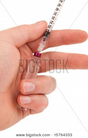 Mano diabética con jeringa médica y ampolla