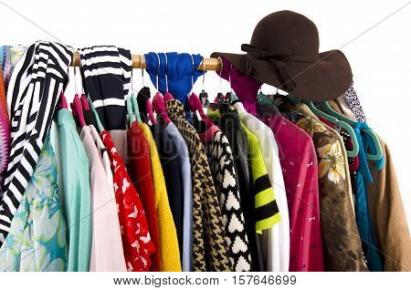 Close up on colorful clothes and hat on hangers in a store. Clothes and accessories hanging on a rack nicely arranged.