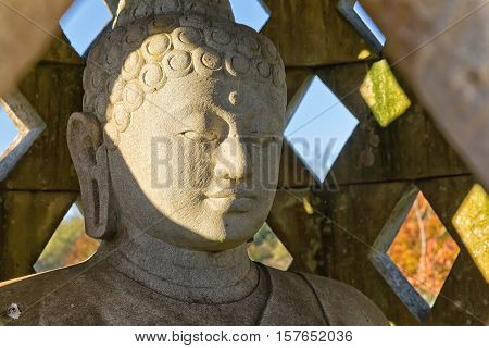 Carved stone buddha statue inside small stupa