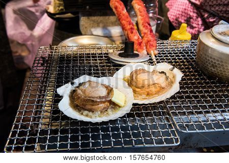 Japanese street food consisting of griddled scallops in a butter sauce at the Tsukiji fish market in Tokyo, Japan