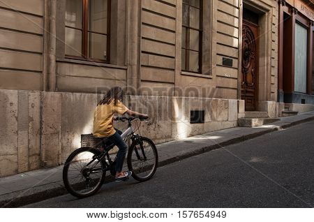 Girl riding her bike on the street in Geneva, Switzerland