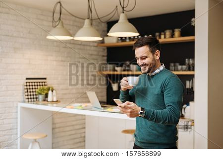 Handsome man enjoying time for internet and coffee.