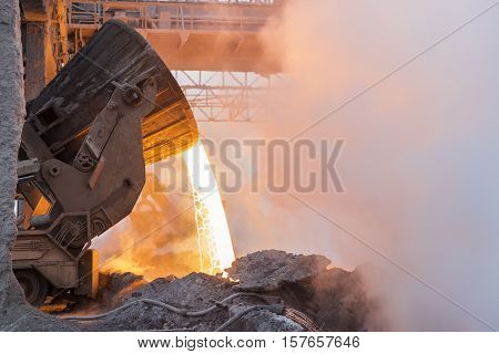 Heavy industry. Part of the process in metallurgy. Pouring the hot melt from the vat.