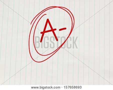 A minus (A-) grade written in red on notebook paper