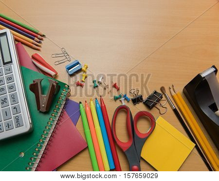 Assortment of school supplies on a wooden background