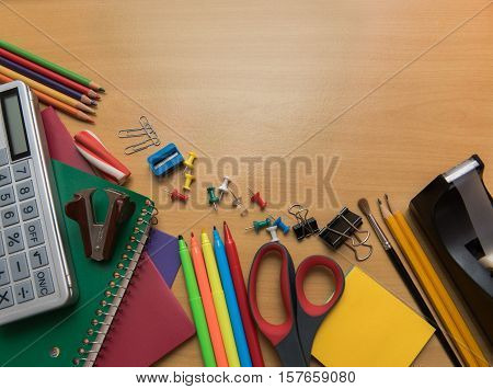 Assortment of school supplies on a wooden background