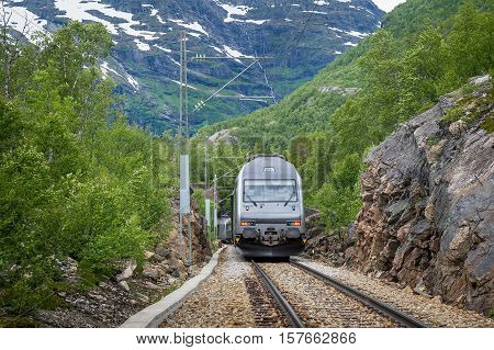 Flamsbana touristic mountain railway train at it's way to Kjosfossen waterfall. Flam, Norway.