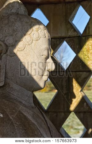Carved stone buddha statue inside small stupa