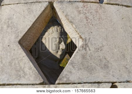 Carved stone buddha statue inside small stupa