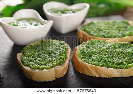 Crunchy tasty bruschetta with pesto sauce on a slate plate