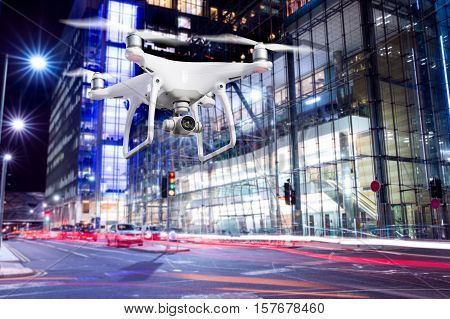 Close up of hovering drone taking pictures of city of London at night