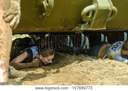 Tyumen, Russia - June 11, 2016: Race of Heroes project on the ground of the highest military and engineering school. Racers move under tank. Caterpillar stage