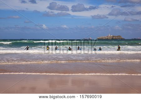 SANTANDER SPAIN - AUGUST 20: Boys teen surfing in Cantabrian sea on August 20 2016