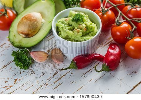 Guacamole sauce and indredients on wood background, copy space