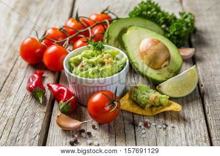 Guacamole sauce and indredients on wood background, copy space