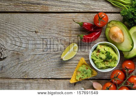 Guacamole sauce and indredients on wood background, copy space