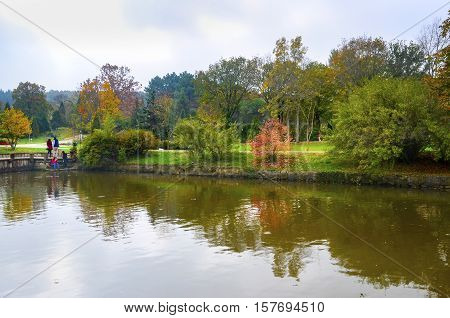 Istanbul Turkey - November 03 2013: Ataturk Arboretum is an arboretum in Bahcekoy Sariyer Istanbul Province. Autumn trees around lake. Fall trees reflected in lake. Autumnal scene with yellow orange and red leaves on trees.