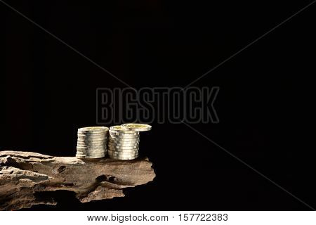 Coins on the old wood and black background.