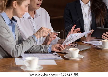 Important conversation. Concentrated female ambitious colleagues discussing the report while sitting in an office and working together.