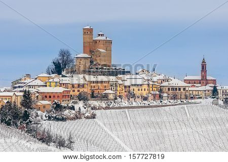 Small town of Serralunga d'Alba on hill covered with snow in Piedmont, Northern Italy.