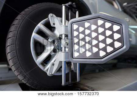 Check it out. Close up of car tyre clamped in alignment machine device while being checked