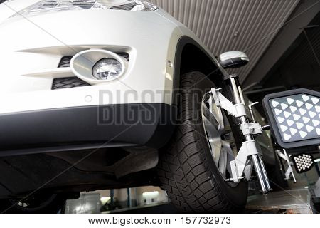 Modern vehicle. Low angle of car tyre clamped in alignment machine device