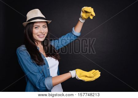 Happy every day. Positive beautiful glad gardener smiling and enjoying gardening while standing isolated on black backgroubd