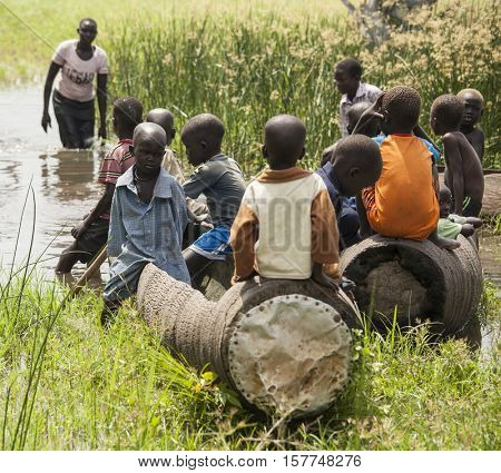 BOR, SOUTH SUDAN-NOVEMBER 2, 2013: Unidentified children play in dugout canoes south of Bor, South Sudan