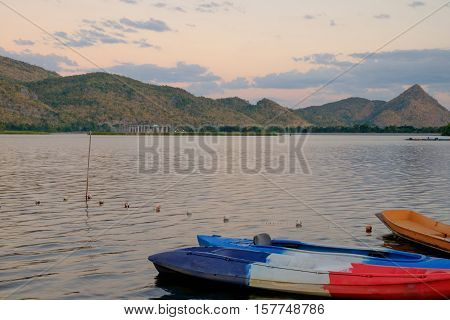 boat in the lake in font of mountain during sunset