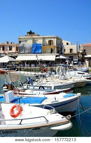 RETHYMNO, CRETE - SEPTEMBER 15, 2016 - View of traditional fishing boats in the inner harbour with waterfront restaurants to the rear Rethymno Crete Greece Europe, September 15, 2016.