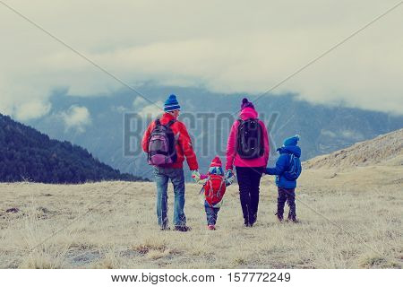 family with two kids hiking in winter snow mountains