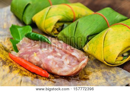 Sour pork Thai northeastern style food which mixed pork rice garlic sugar and salt in banana leaf package.