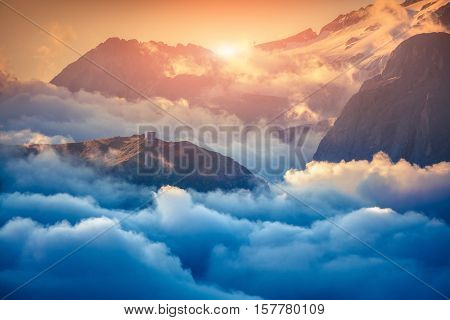 View of the foggy Val di Fassa valley with passo Sella. National Park. Dolomites South Tyrol. Location Canazei Campitello Mazzin. Italy Europe. Retro style.