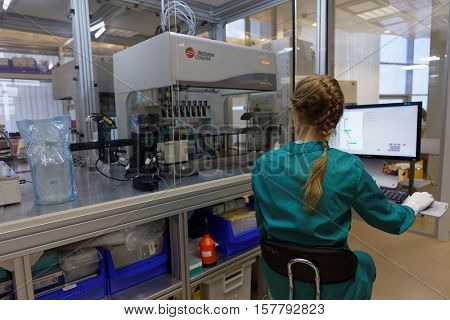 ST. PETERSBURG, RUSSIA - NOVEMBER 16, 2016: Researcher at work with automated station of selection of cultivation condition in the High-Throughput Biotechnology Laboratory of BIOCAD
