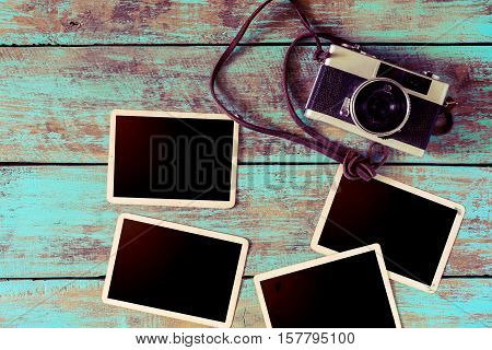 Retro camera and empty old instant paper photo album on wood table - blank photo frame vintage style