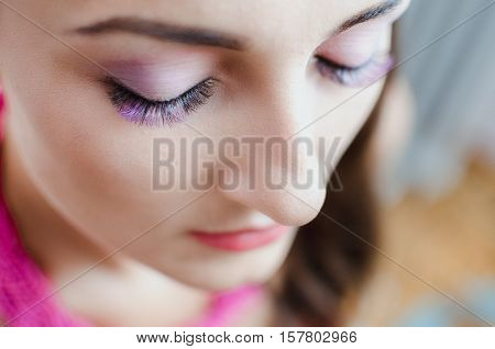 A girl with a beautiful purple eyelashes buried the eye beautiful makeup, fashion