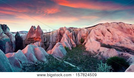 Unreal world of Cappadocia. Sunset in Red Rose valley in April. Cavusin village located district of Avanos in Nevsehir Province in the Cappadocia region of Turkey Asia.