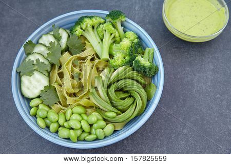 Spinach pasta with cucumber, broccoli, avocado and edamame