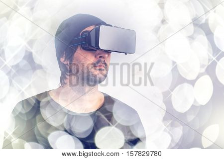 Male actor immersed in experience of virtual reality environment wearing vr goggles augmented-reality headset and enjoying 3d cyberspace multimedia content.