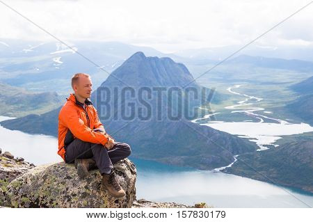 Young man hiking on Besseggen. Happy man enjoy lake and good weather in Norway