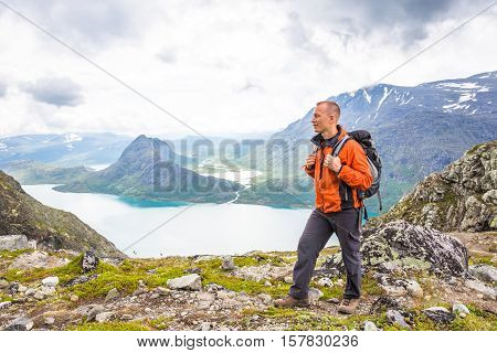 Young man hiking on Besseggen. Happy man enjoy lake and good weather in Norway
