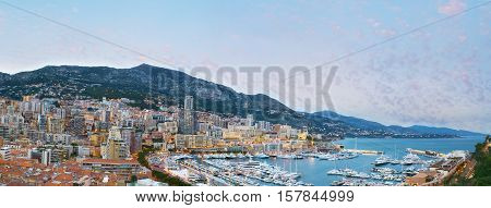 Panorama of Monaco coastline in the evening the Port Hercules surrounded by densely built-up wards of La Condamine and Monte Carlo on the background.