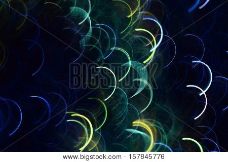 Abstract photo by blue and green semicircular light lines to background.