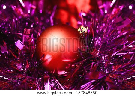 Photo by red christmas ball in the violet tinsel.